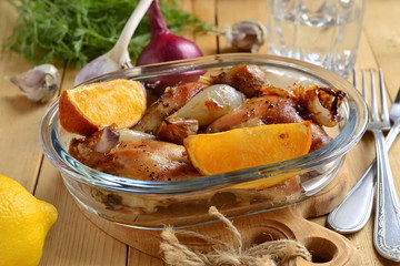 Baked in the oven chicken with orange, garlic and onion