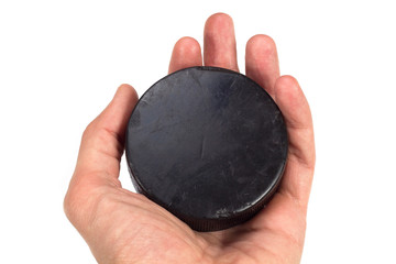 Old hockey puck in hand on white background