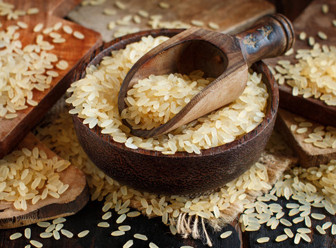 Parboiled rice in a bowl with a wooden spoon