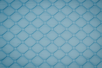 Blue quilted fabric. The texture of the blanket	