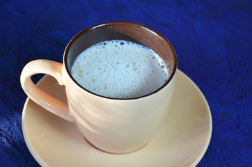 Cup of cappuccino coffee or latte on the dark blue background