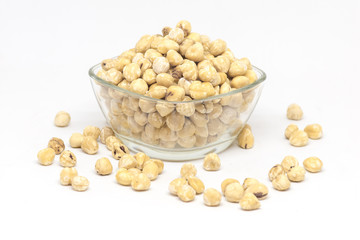 bowl with raw hazelnuts kernels on white background