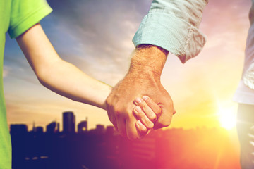 family, generation and support concept - close up of grandfather and grandson holding hands