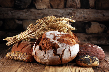 Different kinds of bread and bread rolls on board from above. Kitchen or bakery