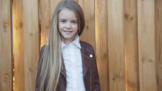 Portrait of the young, pretty girl smiles at camera at fence. 4K