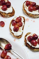 Ricotta and roasted grapes toasts isolated on white