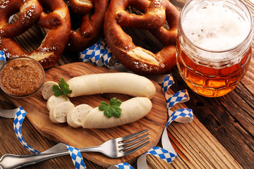 Bavarian veal sausage breakfast with sausages, soft pretzel and mild mustard on wooden board from Germany