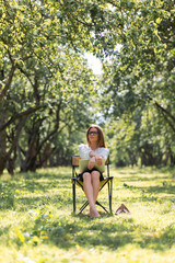Business woman with laptop in the park sitting on a folding chair