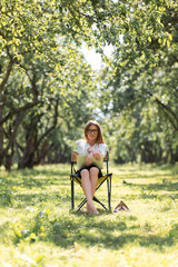 Business woman with laptop in the park sitting on a folding chair