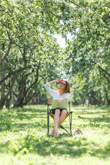 Business woman with laptop in the park sitting on a folding chair