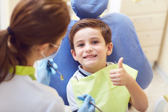 A Child With A Dentist In A Dental Office. Dental Treatment In A Children's Clinic.