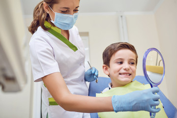 A child with a dentist in a dental office. Dental treatment in a children's clinic.