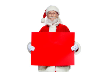 Christmas. The kind Santa Claus in white gloves holds an empty cardboard of red color. Place for advertising, for text, empty space. Copy-paste. Isolated on white background.