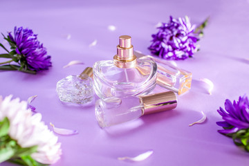 Obraz na płótnie Canvas Bottles of perfume with purple and white flowers