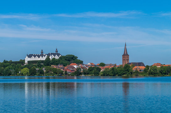 Panorama Blick auf die Stadt Pl&ouml;n vom Pl&ouml;ner See. Wundersch&ouml;ne Aussicht auf das Pl&ouml;ner Schloss und den Kirchturm von Pl&ouml;n.