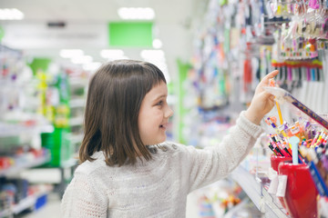schoolgirl choosing office supplies