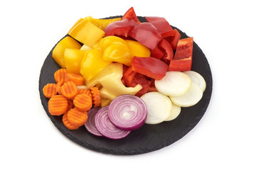 Fresh vegetables on slate shale plate, isolated on white background.