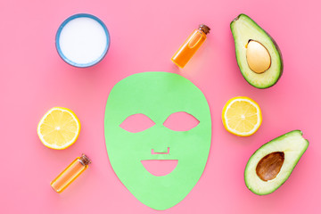 Skin care. Facial mask, cream and lotion near avocado and lemon on pink background top view