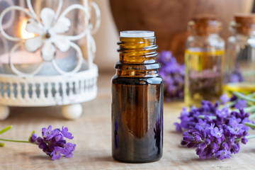 Fototapeta na wymiar A bottle of lavender essential oil with fresh blooming lavender
