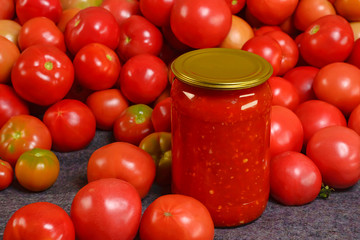 Fresh juicy red tomatoes with tomato paste in a glass jar