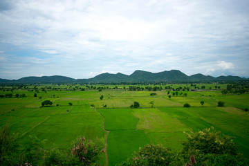 Fototapeta na wymiar landscape with green field, mountains and blue sky