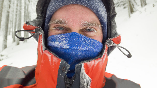frozen man portrait in winter scene, mountain landscape