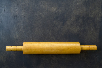 Rolling pin on a dark wooden background.