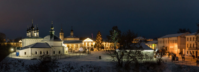 Fototapeta na wymiar Suzdal, Russia. Pyatnitskaya church and Shopping arcade Gostiny Dvor of Suzdal Kremlin at night in winter