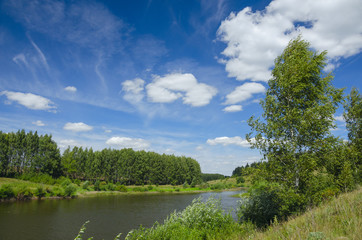 Sunny summer landscape with river,green hills and beautiful clouds in blue sky.Tula region,Russia. 