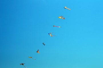 fila di aquiloni su cielo azzurro