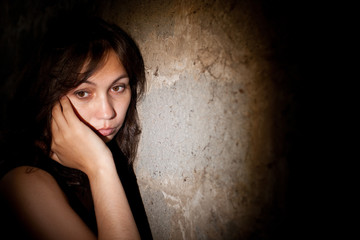 Teenager girl with depression alone in the dark room.