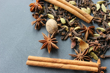 Fototapeta na wymiar Various Spices background. Cinnamon sticks and anise stars close-up on wood background. Copy space