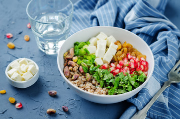 Barley pomegranate raisins feta salad in a bowl