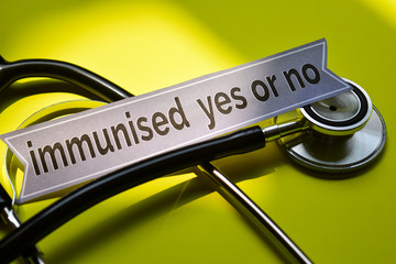 Closeup immunised yes or no with stethoscope concept inspiration on yellow background