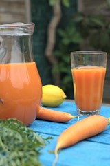 Healthy eating,tasty and vegetable concept-natural homemade carrot juice in glass on an old wooden blue table in the background.