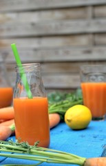Healthy eating,tasty and vegetable concept-natural homemade carrot juice in glass on an old wooden blue table in the background.