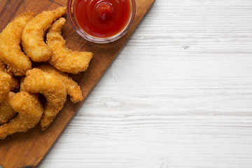 Fried shrimps tempura with sauce on wooden board over white wooden background, overhead view. Copy space.