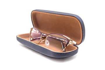 Golden sunglasses in a brown case at an angle on a white background