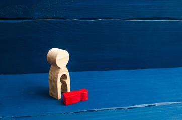 A wooden figure of a woman with a void from which a red child fell. The concept of the loss of a...