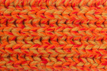 Winter orange knitted scarf close-up.