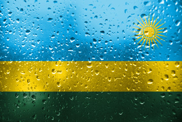 Texture of Rwanda   flag on the glass with drops of rain.