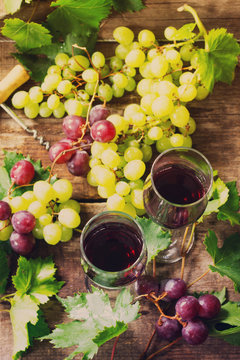 Wine background. Red wine in glasses, bottle, grapes on vintage background, wine concept.