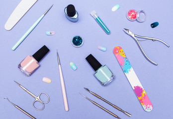 Nail work flat lay concept. Stylish trendy female manicure. top view on jars with gel-nail varnish and a set of tools for manicure and pedicure, sequins, glitter and false nails