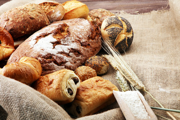 Different kinds of bread and bread rolls on burlap sack. Kitchen or bakery poster design