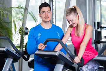Fototapeta premium Ausdauertraining im Fitnessstudio, Mann und Frau beim Sport 