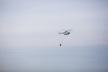 Fire in forest. Helicopter dpirs and drops water in epicenter of incident