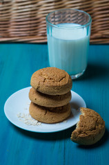 oatmeal cookies lie next to a glass of milk on a wooden background