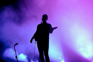 Silhouette of an unregnizable guitarist and singer