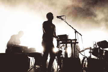 Silhouette of an unregnizable singer and keyboard player