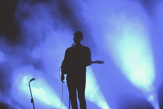 Silhouette of an unregnizable guitarist and singer